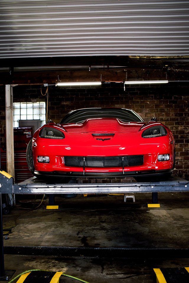 front view of red customized race car on service bay