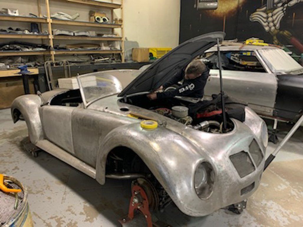 front view of car with hood open and tires removed