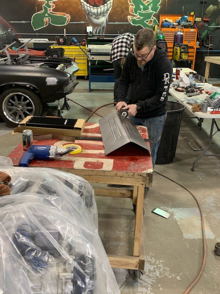 mechanic detailing car part on workbench