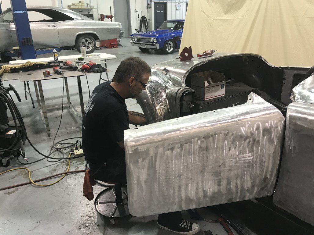 worker detailing car while car door is open