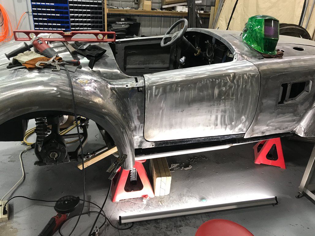 side view of chrome colored car with tires removed