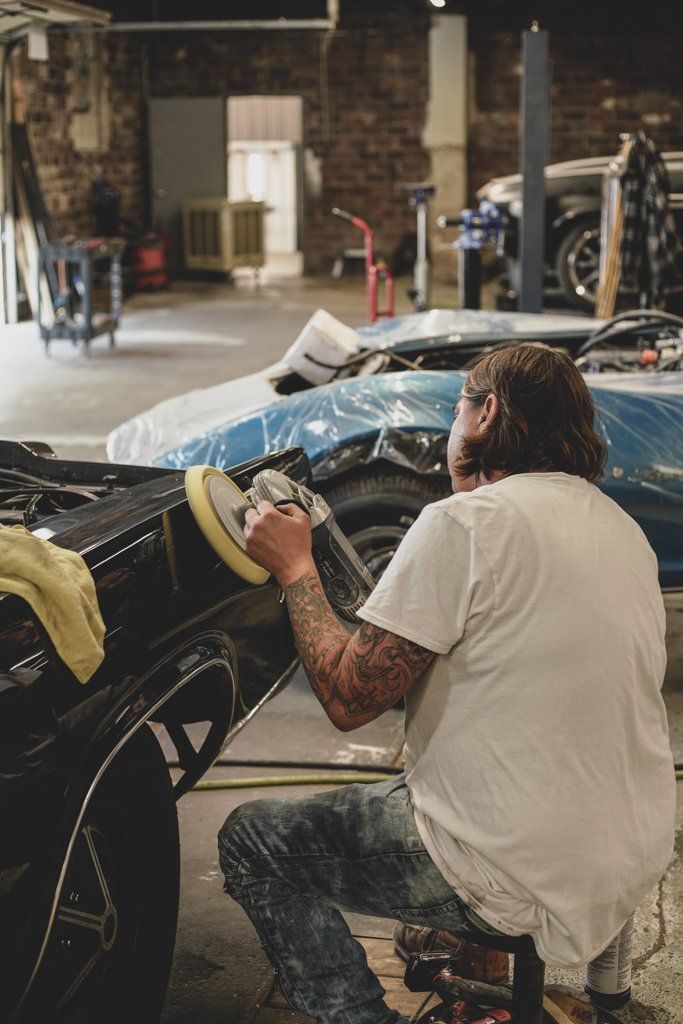 mechanic buffering car part from the inside of car