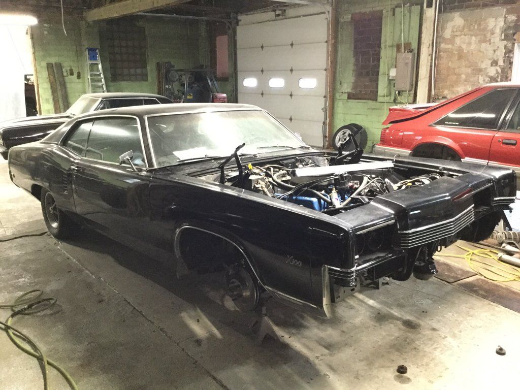 full view of car with engine exposed and wheels removed