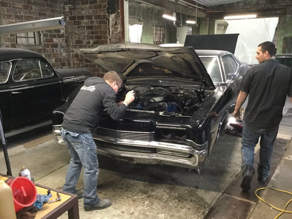 mechanics working on car together