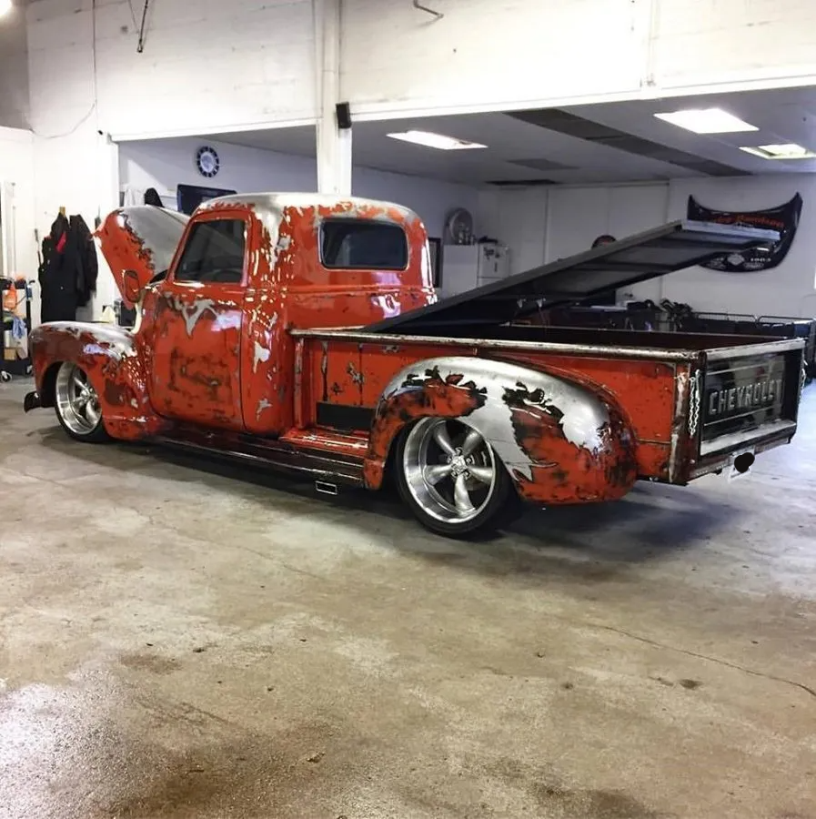 custom 1954 red chevy mitch pickup truck inside garage