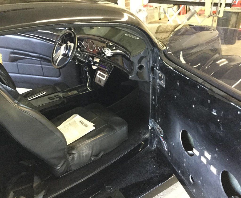 interior view with open door of custom black 1937 ford tudor hot rod