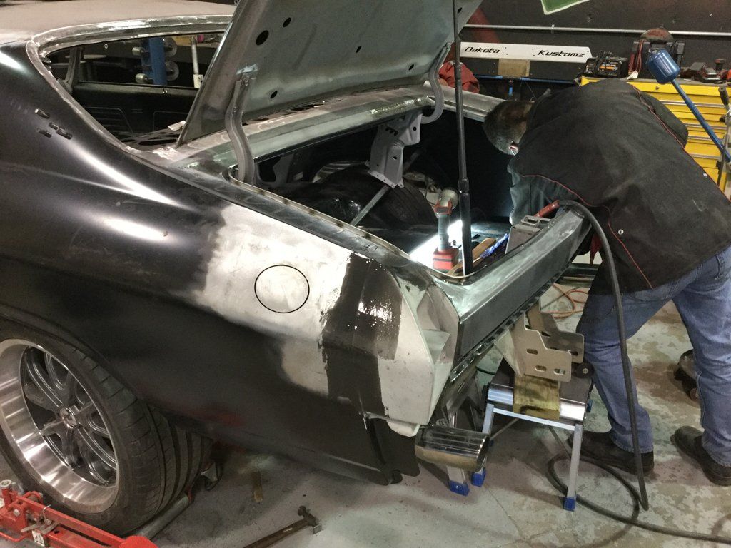 mechanic reaing into rear of car with bright light