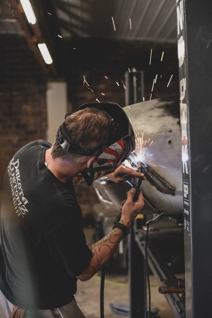 mechanic using torch on car for detail