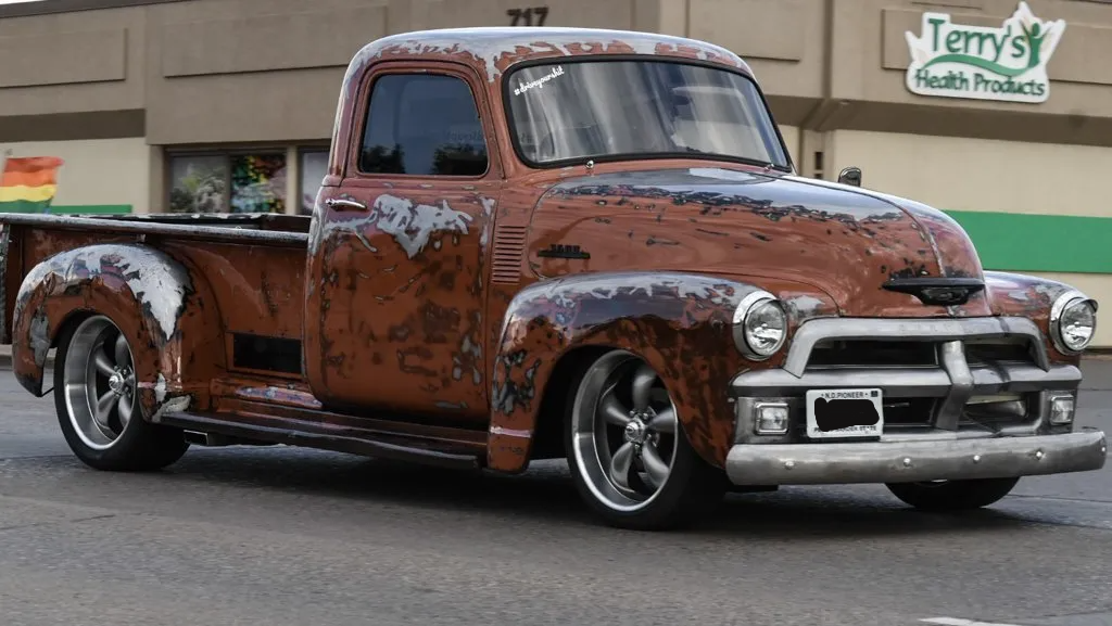 red customized pickup cruising down street