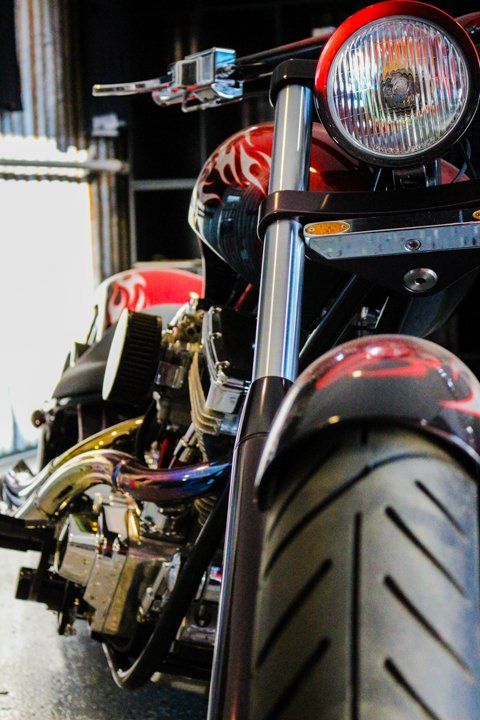 close up view of orange custom motorcycle headlight and wheel