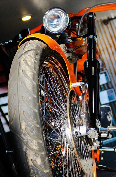close up view of orange custom motorcycle wheel
