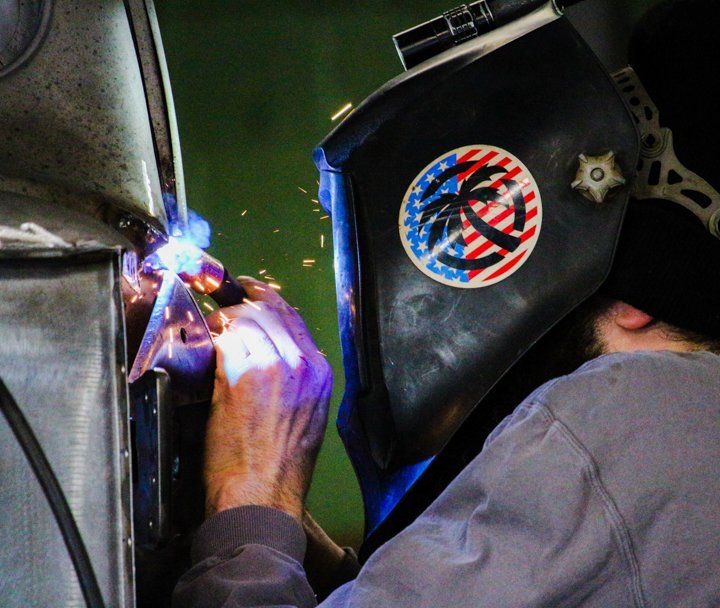 Dakota Kustomz worker wearing welding mask welding custom car part