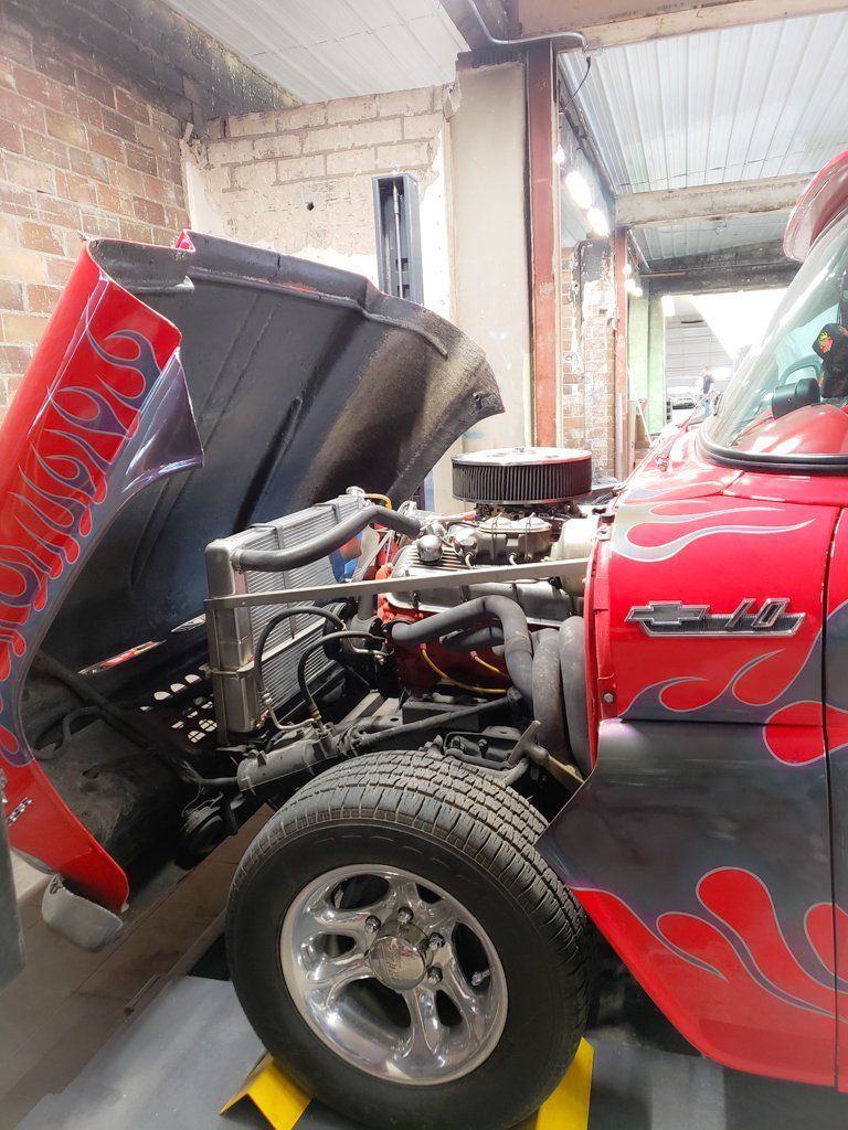 side view of engine of 1962 red customized truck with grey flames