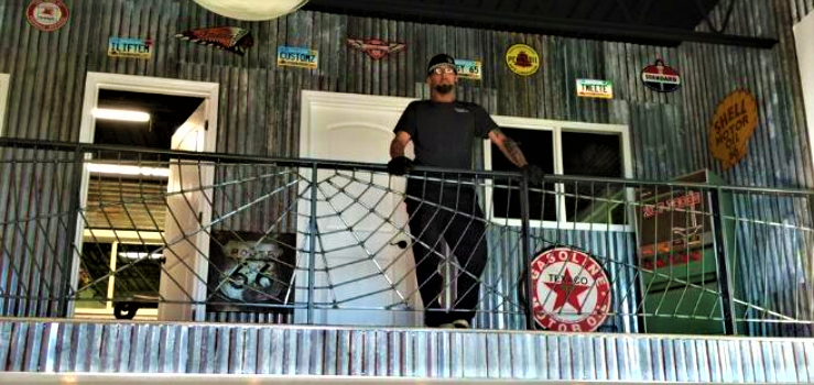 owner travis leaning against custom railing on second floor