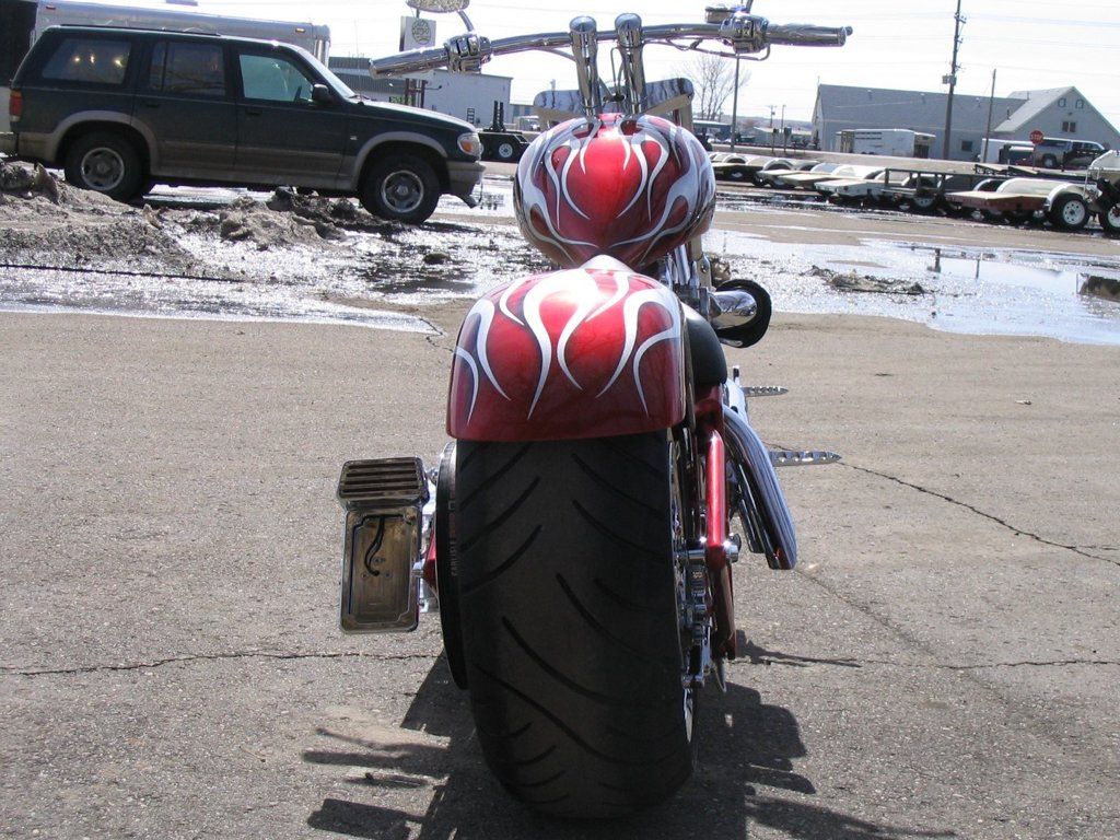 rear view of customized red and chrome motorcycle chopper outdoors