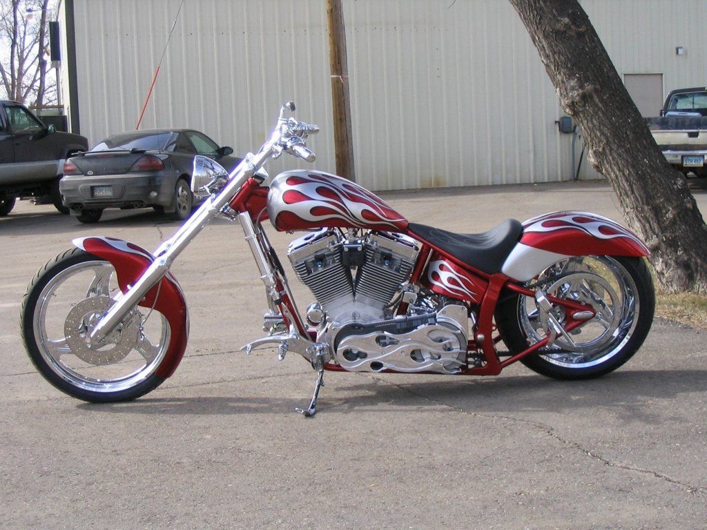 side view of customized red and chrome motorcycle chopper outdoors