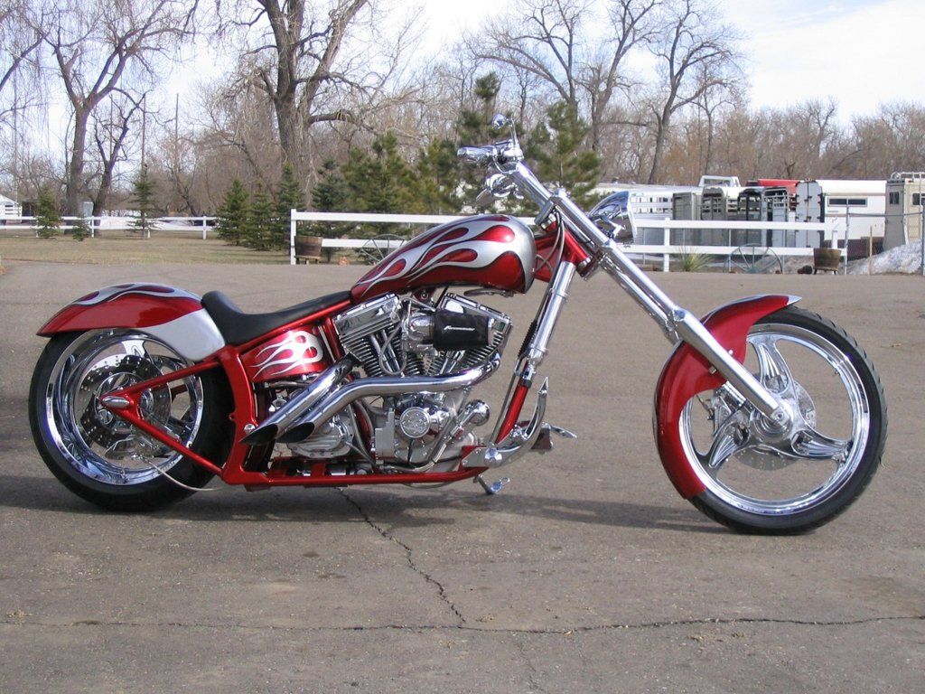 side view of customized red and chrome motorcycle chopper outdoors