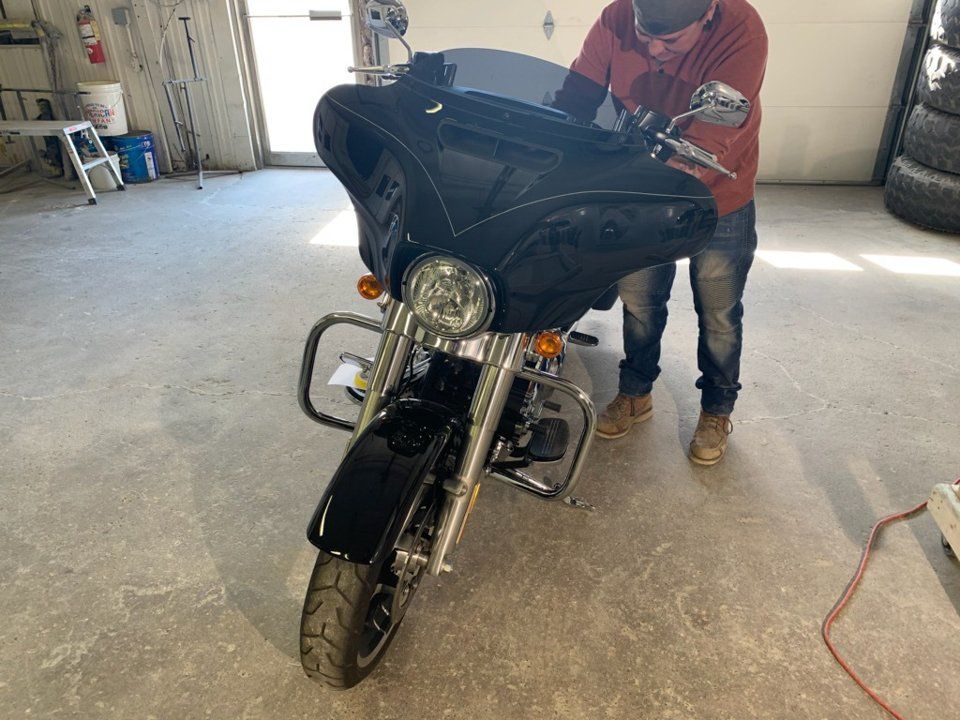 painter applying customization to black motorcycle