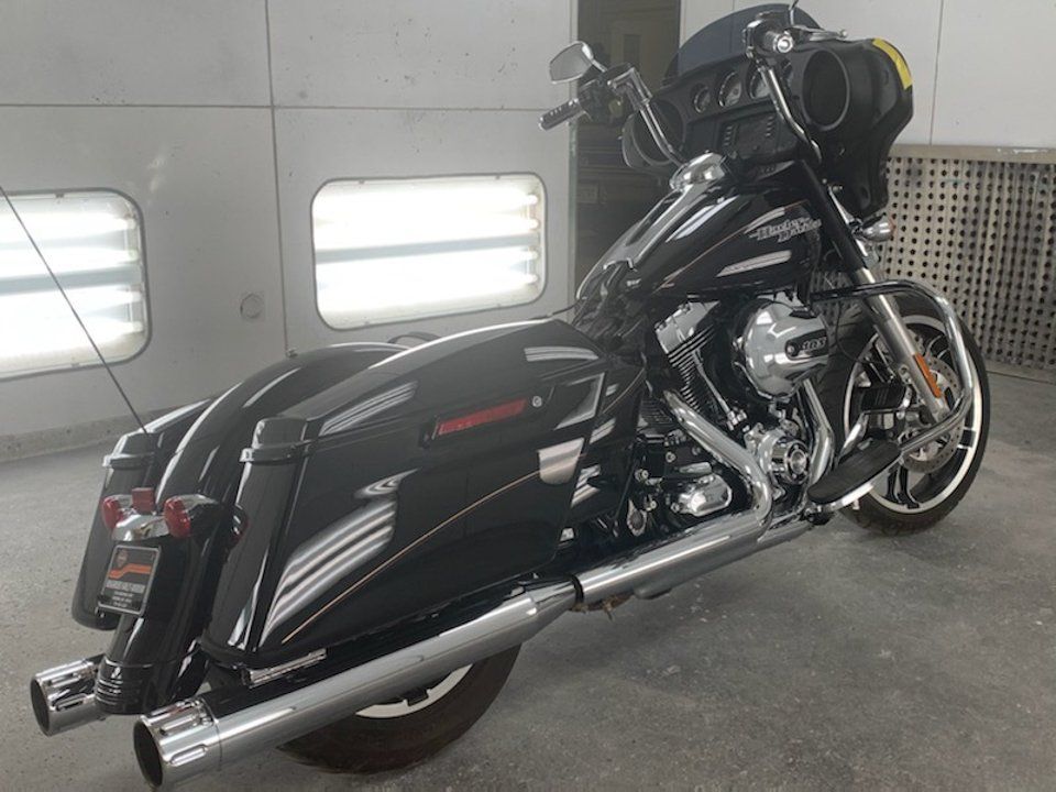 rear side view of customized black motorcycle with yellow and purple pinstriping