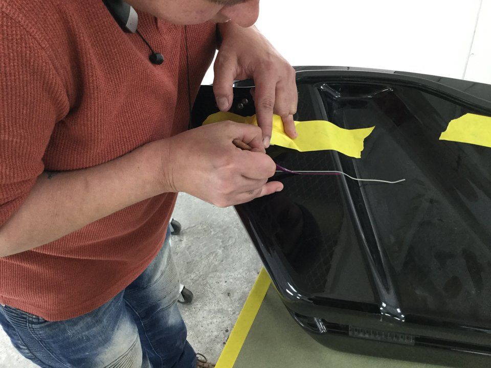 close up of painter applying customization on black motorcycle
