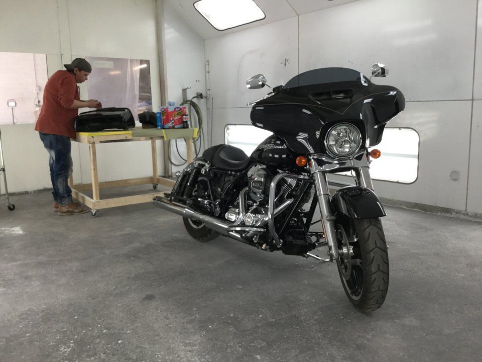 motorcycle with finished pinstriping with worker working in the background