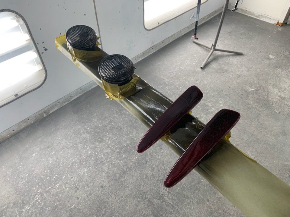 tinted car lights on drying rack in painting room