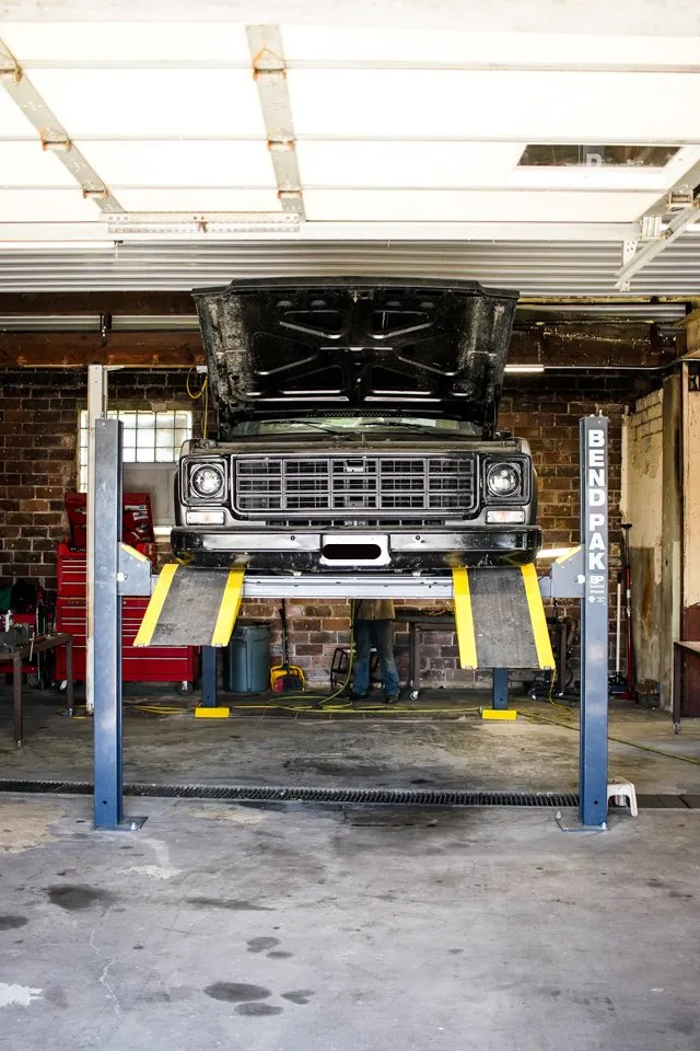 truck suspended and raised on service bay
