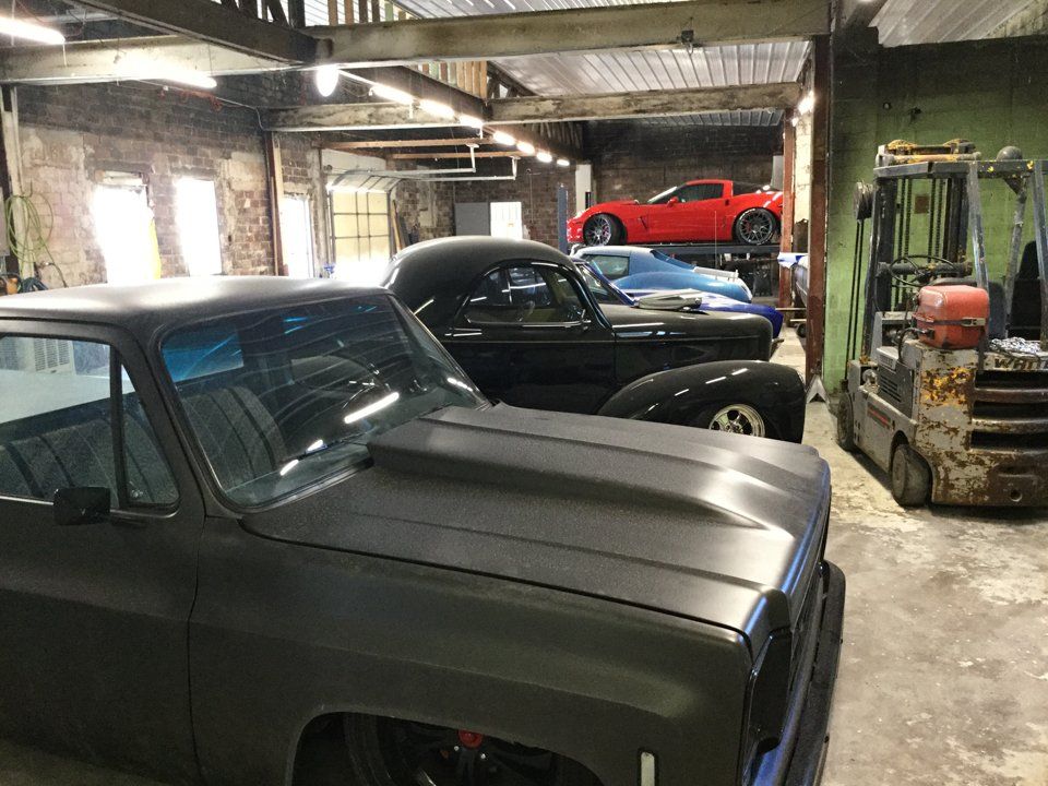 line up of customized cars in garage service bay