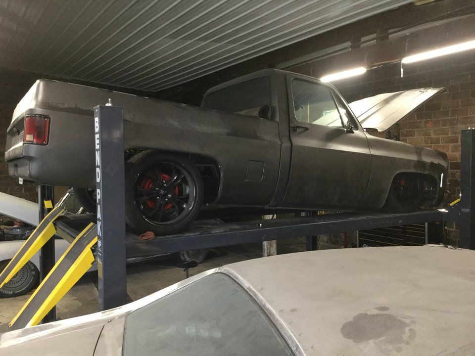 side view of truck lifted on service bay