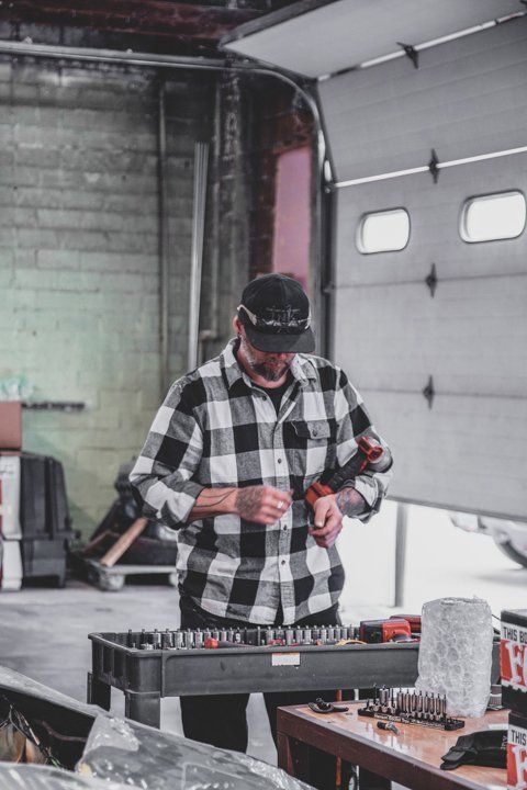 mechanic adjusting tools in Dakota Kustomz car shop