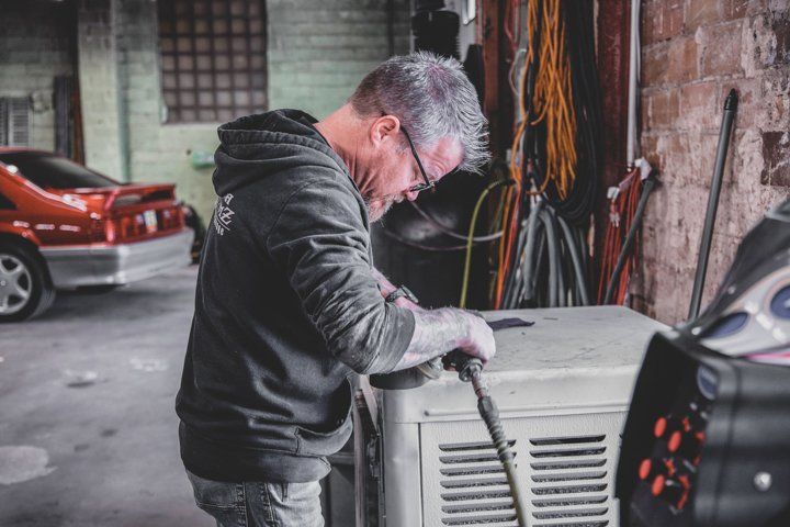 mechanic adjusting tools in Dakota Kustomz car shop