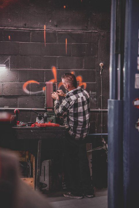 mechanic polishing and sanding in Dakota Kustomz car shop