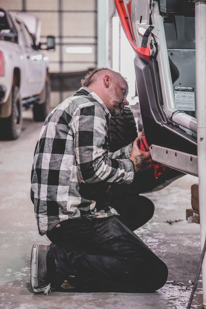 mechanic adjusting something near the wheel