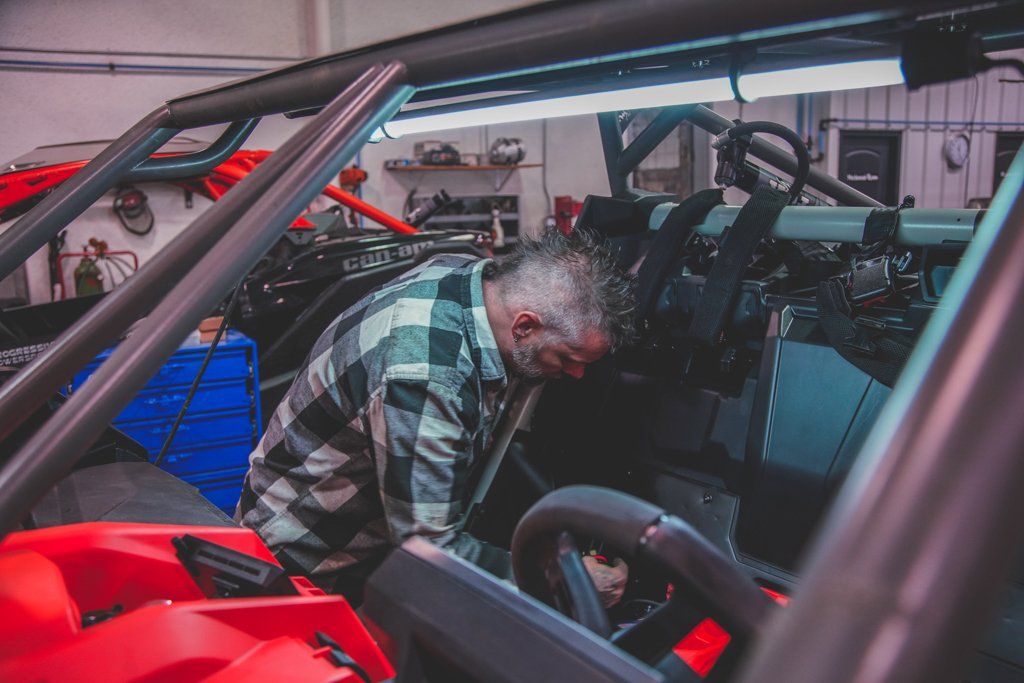 mechanic reaching into interior of custom 2021 red and black maverick