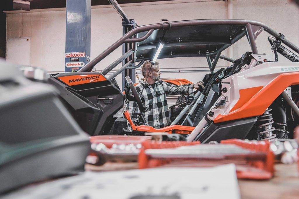 mechanic in car shop looking in the distance