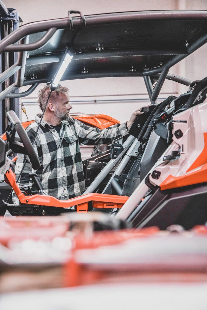 mechanic in car shop looking in the distance