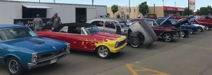 outdoor line up of custom muscle cars and hot rods