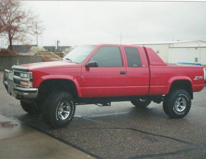 custom red pickup truck with lift kit