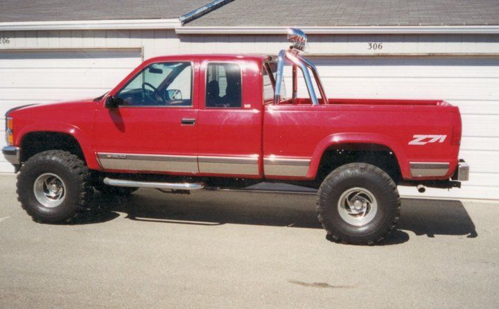 custom red pickup truck with chrome and lift accessories