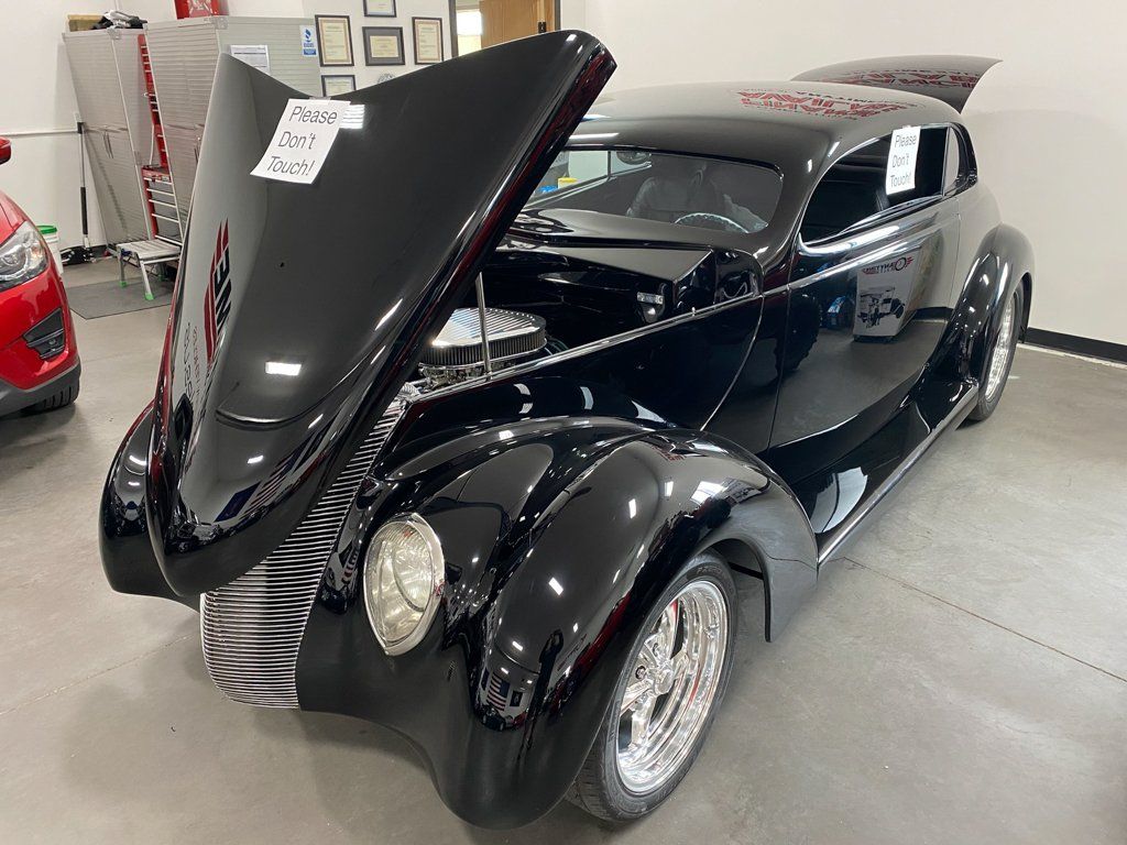 custom black 1937 ford tudor hot rod with hood opened