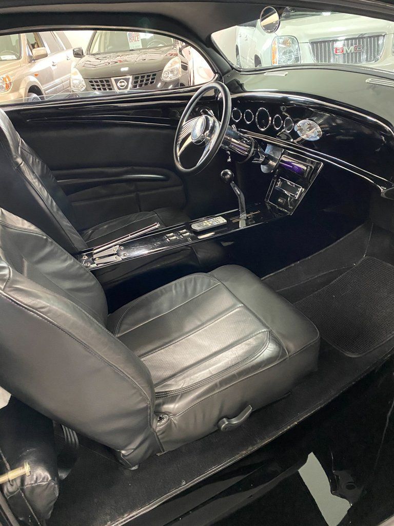 interior view of steering wheel and seat for custom black 1937 ford tudor hot rod