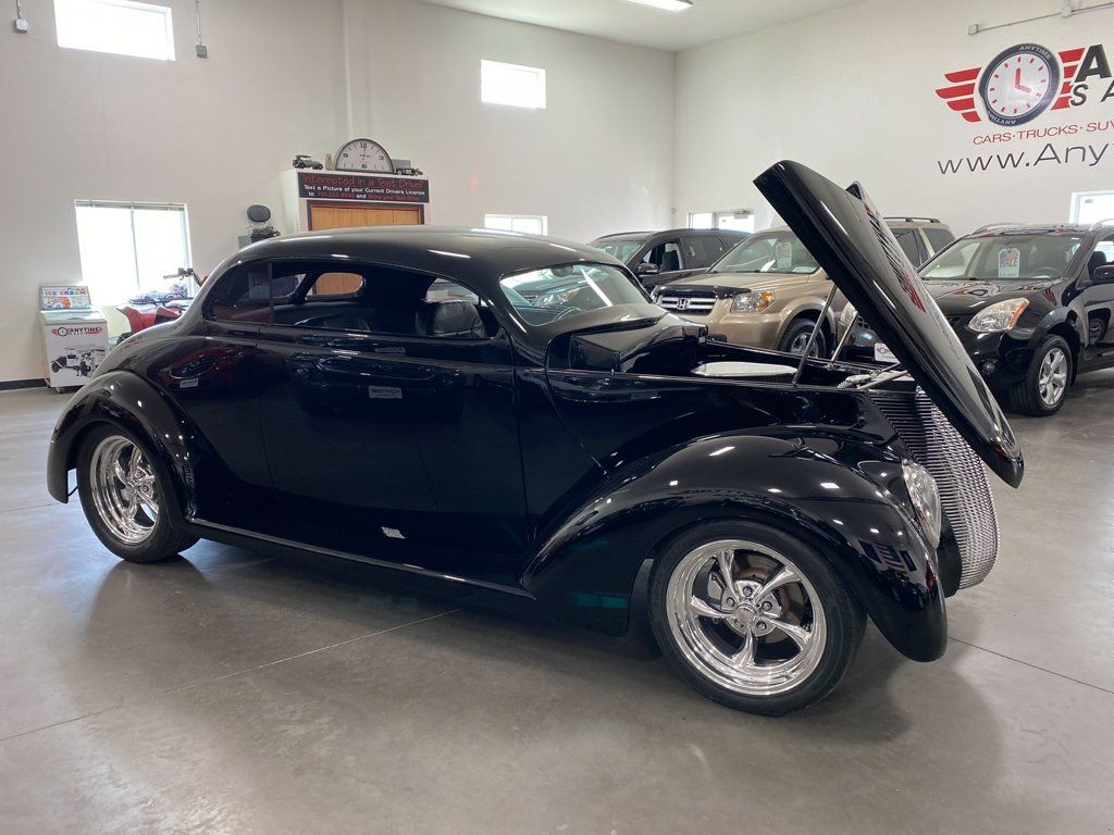customized 1937 black ford tudor side view with hood open