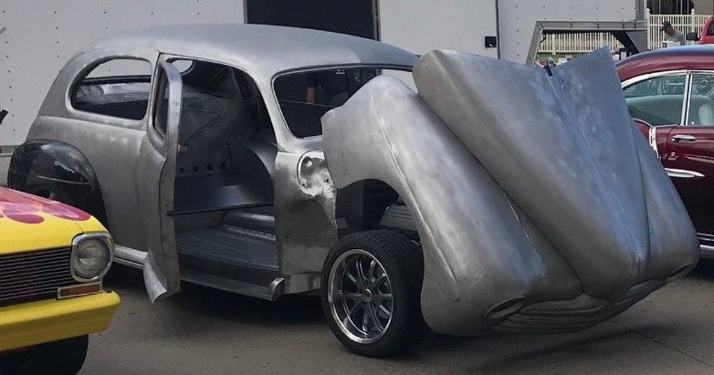 front side view of sedan with hood opened and doors open