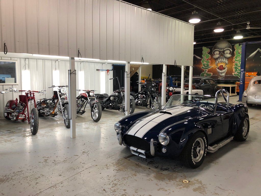 hot rod in garage in front of motorcycles