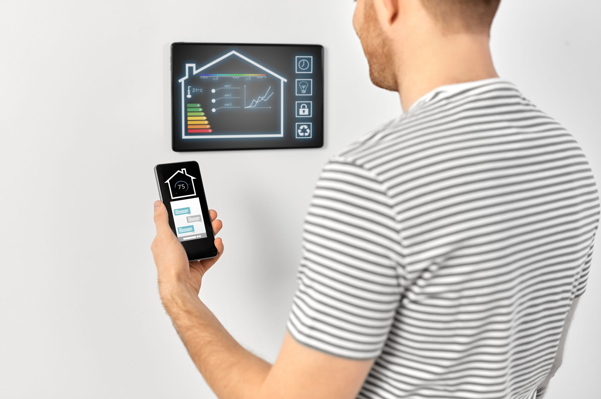 A man is using a smart phone to control a smart home.