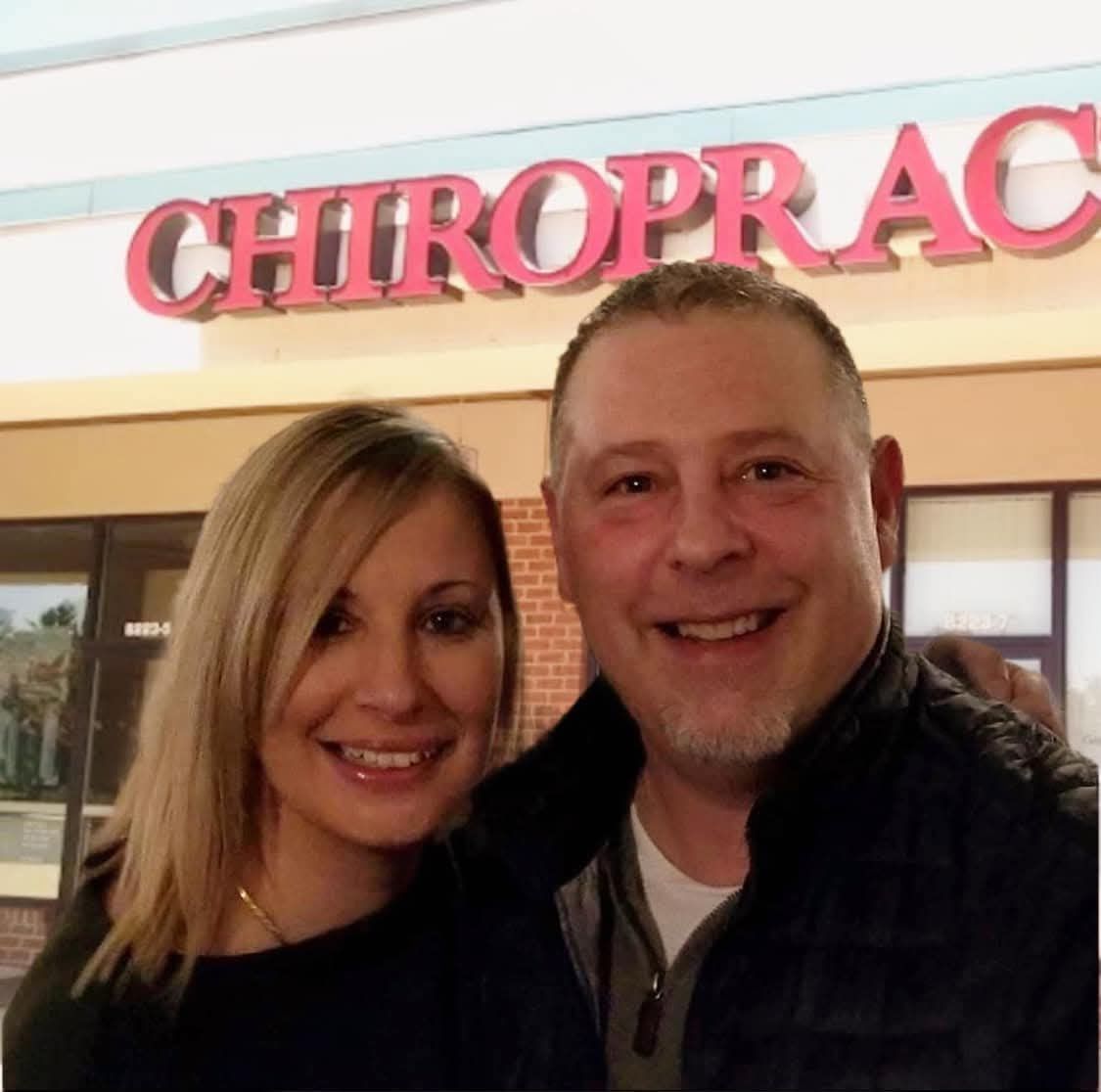 Dr. Joe and wife Trish smiling in front of their chiropractic office located in the Giant Shopping Center on Elliott Road