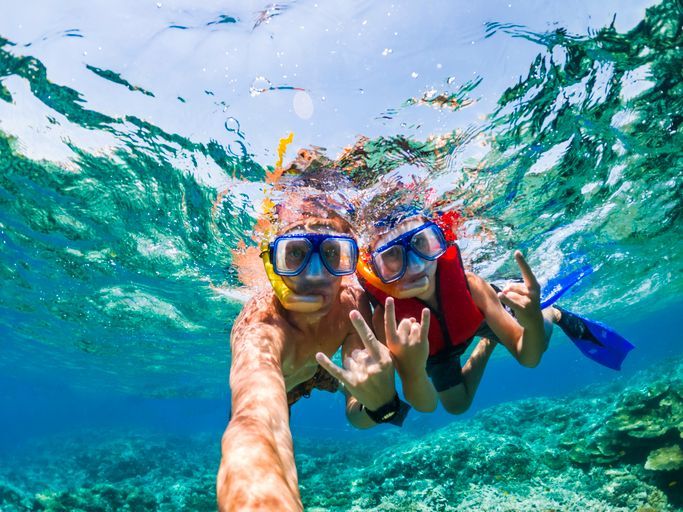 Un uomo e un bambino stanno facendo snorkeling nell'oceano.