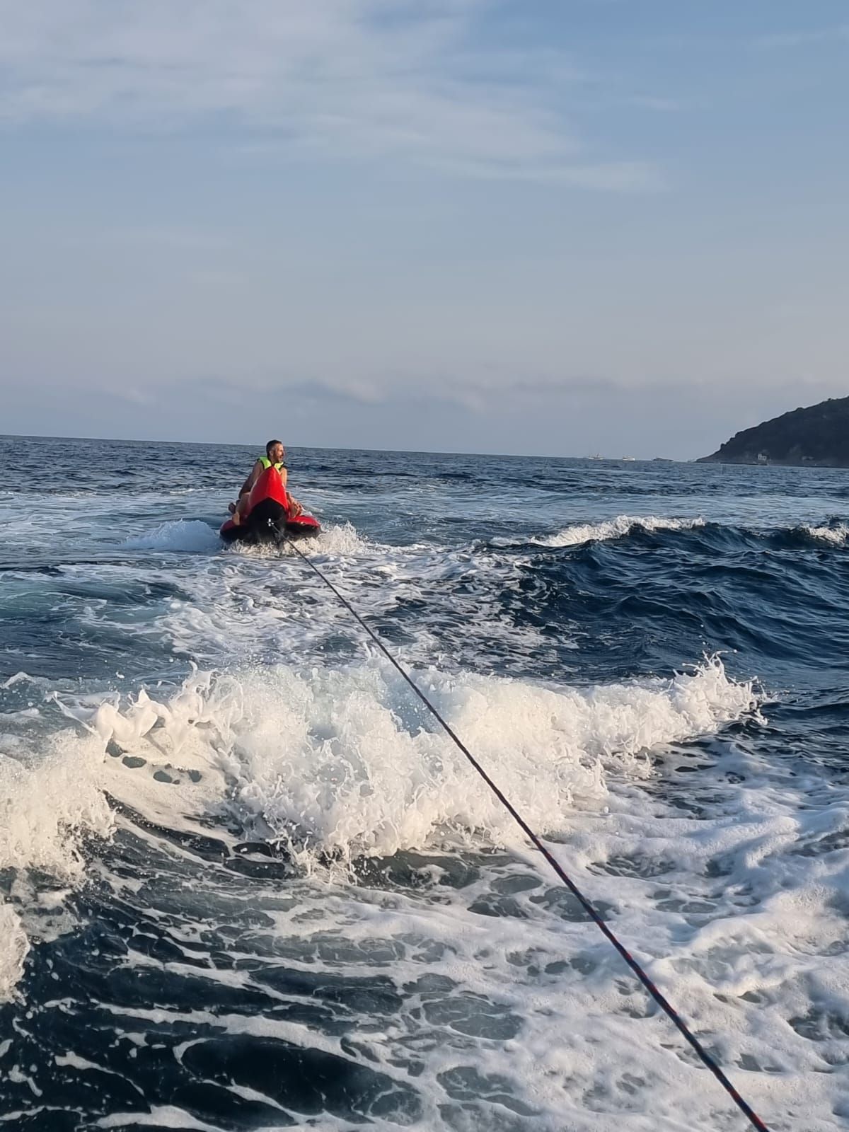 Una persona viene trainata da una barca nell'oceano.