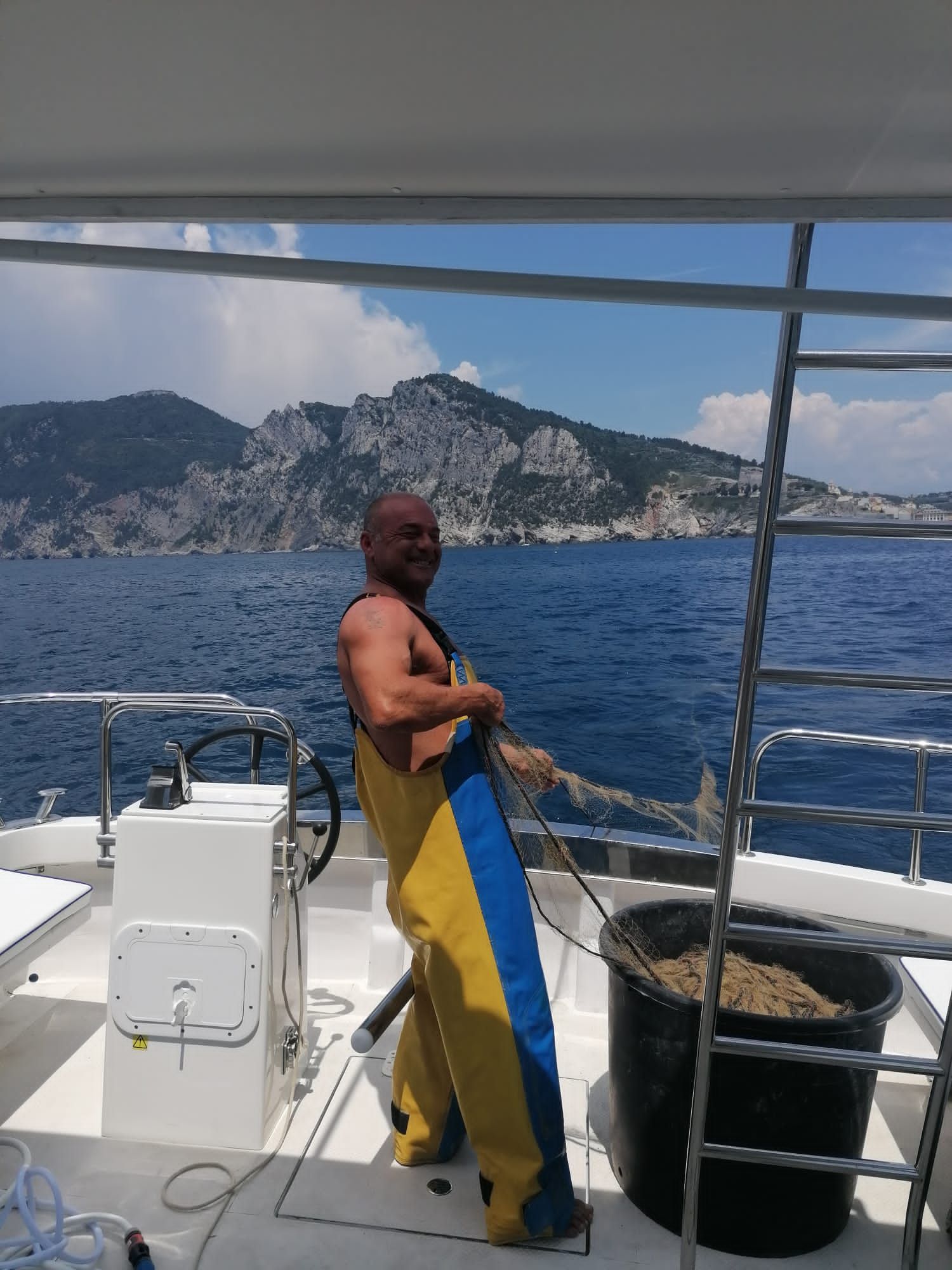 Un uomo è in piedi sul ponte di una barca e tiene in mano una corda.