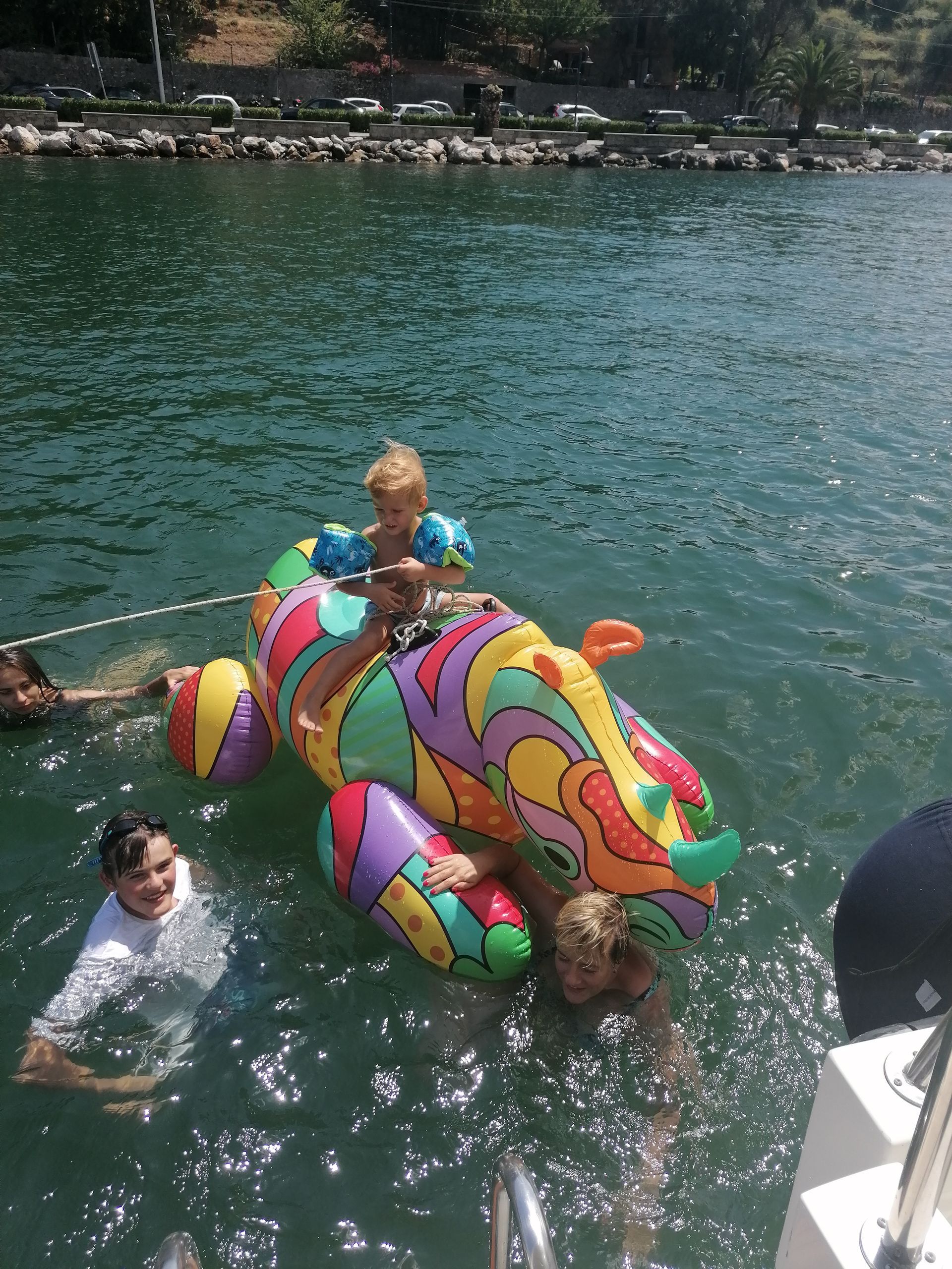 Un gruppo di bambini sta giocando in acqua su un galleggiante colorato